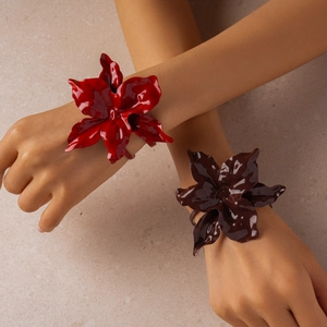 Detail of red and brown layered flower arm cuffs with a high-gloss painted finish