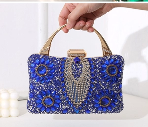 Detailed macro of royal blue rhinestone evening bag with floral gems and gold handle