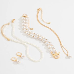 Detail of multi-layered pearl necklace and matching jewelry set with gold accents