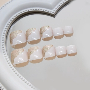 Sparkly champagne gold glitter toe nail tips with irregular wave design on white base