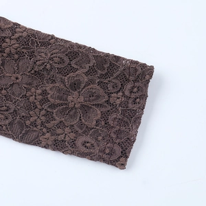 Macro view of coffee brown lace floral texture on long sleeve slim fit bodycon dress