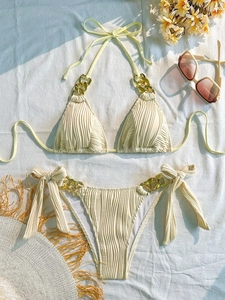 Chic cream halter bikini set with gold chain accents and ribbed texture on white linen