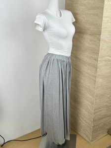 Detail of white cotton T-shirt and grey irregular long skirt on a display mannequin