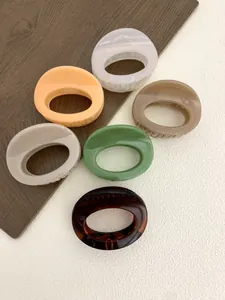 Close-up of six-piece oval claw clip set in glossy resin and tortoiseshell finishes