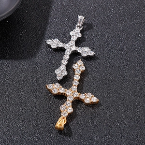 Gros plan de pendentifs croix hip hop en or et argent avec zircons sur fond texturé noir
