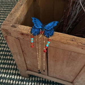 Détail de la pince à cheveux papillon bleu roi brodé avec des franges à perles dorées