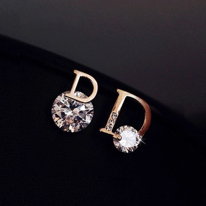 Macro shot of 18K gold letter D earrings featuring a brilliant round-cut cubic zirconia
