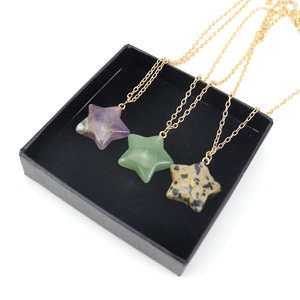 Natural crystal star pendant necklaces in amethyst and aventurine on black velvet display