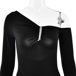 Detail of black one-shoulder long sleeve dress with rhinestone accents on the chest