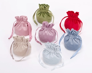 Close-up of small colorful velvet drawstring pouches for jewelry and gifts in seven soft shades