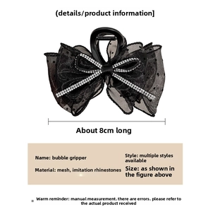 Détail d'une pince à cheveux en dentelle noire de 8 cm avec strass et résille