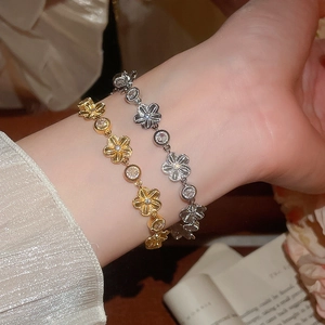 Détail de bracelets fleurs en zircon en finitions or et argent portés par un mannequin