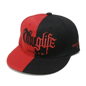Detail of red and black snapback hat featuring Thuglife and Outlaw gothic embroidery