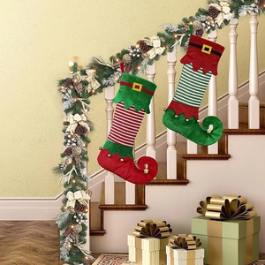 Elf-style Christmas stockings with red green stripes and bells on festive stairs