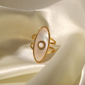 Gros plan détaillé d'une bague ovale dorée avec perle blanche et motifs de soleil