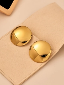Detailed close-up of chunky gold bean stud earrings with a polished mirror finish surface