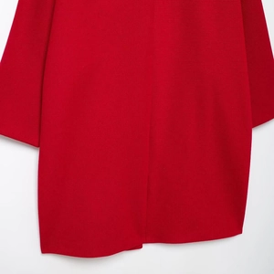 Close-up of vibrant red wool blend coat featuring premium textured fabric and clean seams
