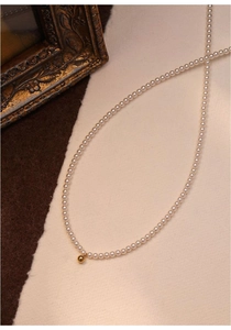 Detail of freshwater baby pearl choker with minimalist 14K gold-filled ball pendant