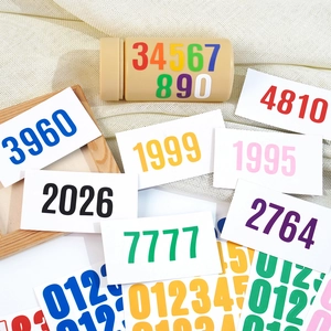 Macro view of colorful 1-inch vinyl numbered stickers with matte finish on beige fabric