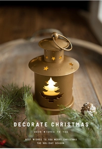 Close-up of golden Christmas lantern featuring hollowed-out star and tree patterns