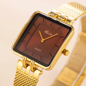 Detailed close-up of a square gold watch with a brown dial and mesh strap