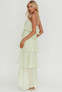 Detail of light green chiffon tiered maxi dress featuring an elegant backless halter neck