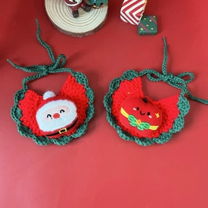 Detailed view of hand-knitted Christmas pet bibs with Santa Claus and apple designs