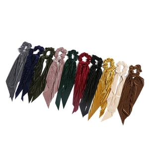 Corduroy bow scrunchies with long streamers in 10 assorted colors on a white background