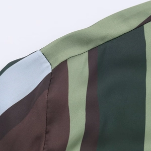 Detailed close-up of striped satin shirt shoulder seam with green and brown vertical lines
