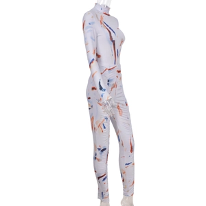 Detail of white tight jumpsuit with blue and orange tie-dye print and high collar