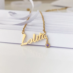Macro shot of gold name necklace Lolita with purple birthstone and elegant script