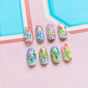 Macro view of 5D floral nail stickers featuring tulips, checkered patterns and pearls