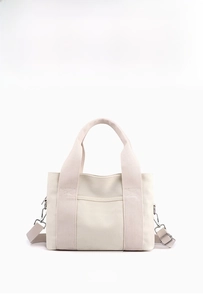 Front view of beige canvas tote bag with reinforced handles and adjustable strap