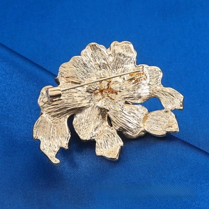 Detailed back view of golden peony brooch showing secure pin and brushed texture