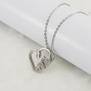 Detailed shot of hollow heart pendant with sparkling LOVE lettering and silver chain