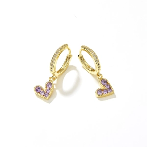 Detail of gold heart earrings featuring purple cubic zirconia stones on white background