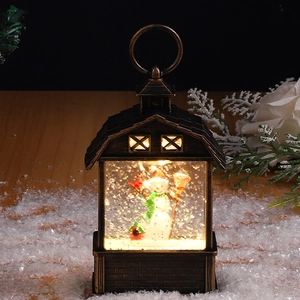 Close-up of bronze Christmas barn lantern with snowman scene and swirling snow effect