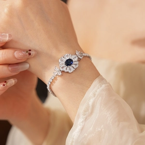 Detail eines Blumen-Armbands mit blauem Edelstein und weißen Zirkoniasteinen