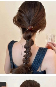 Detailed back view of a brown beaded spiral hair tie securing a ponytail stylishly