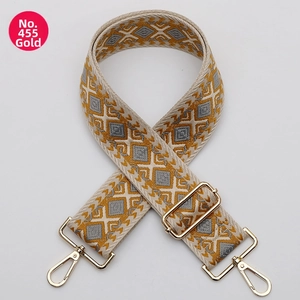 Close-up of number 455 woven geometric guitar strap with gold metal swivel hooks