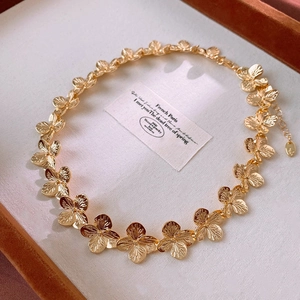 Macro view of golden flower chain necklace with brushed texture on elegant jewelry box