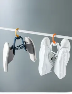 Rotating blue and white shoe drying racks with orange hooks hanging on a balcony rod