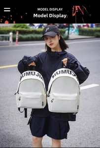 Outdoor shot of white water-resistant nylon backpacks with black MUMUJIA lettering detail