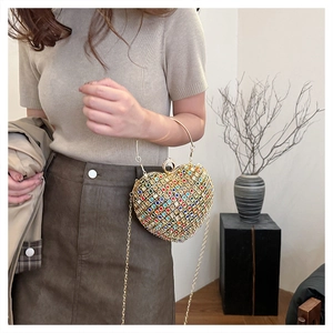 Detail of a sparkling heart-shaped evening clutch with colorful rhinestones and metal ring