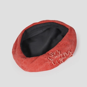 Detailed view of the red washed denim beret featuring raw-edged floral patch applique