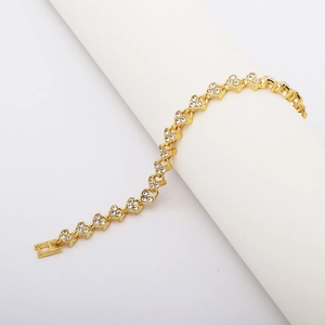 Detail of gold-plated roman bracelet featuring white zircon flower clusters on a white stand