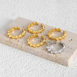 Minimalist gold and silver heart-shaped adjustable open rings set on stone tray