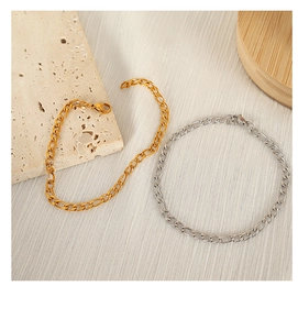 Detailed shot of Figaro chain bracelets in gold and silver finishes on textured background