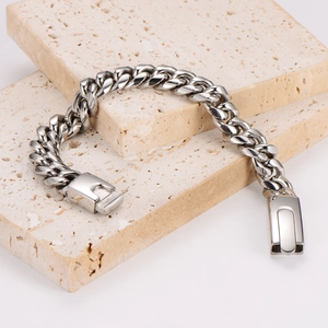 Rugged silver stainless steel cuban link bracelet on beige travertine stones
