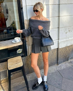 Détails d'un ensemble pull en maille à épaules dénudées gris foncé et jupe courte plissée